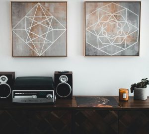 Sideboard with stereo and speakers and artwork on walls