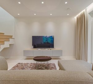 Modern white lounge with contemporary wooden and glass staircase