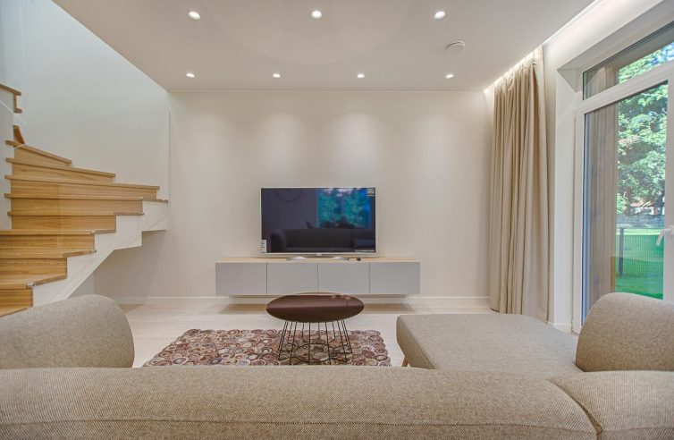 Modern white lounge with contemporary wooden and glass staircase