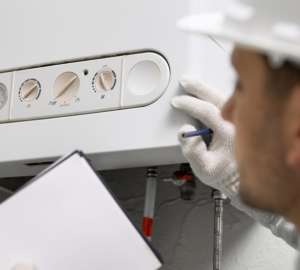 Man in white safety hat looking at a boiler