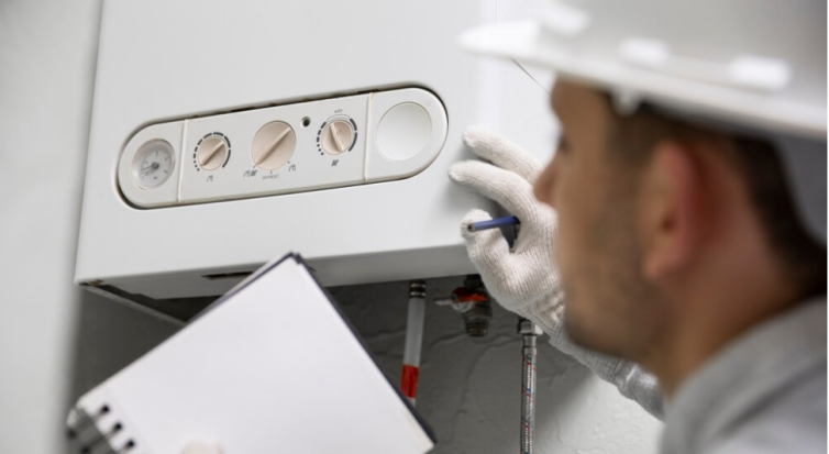 Man in white safety hat looking at a boiler