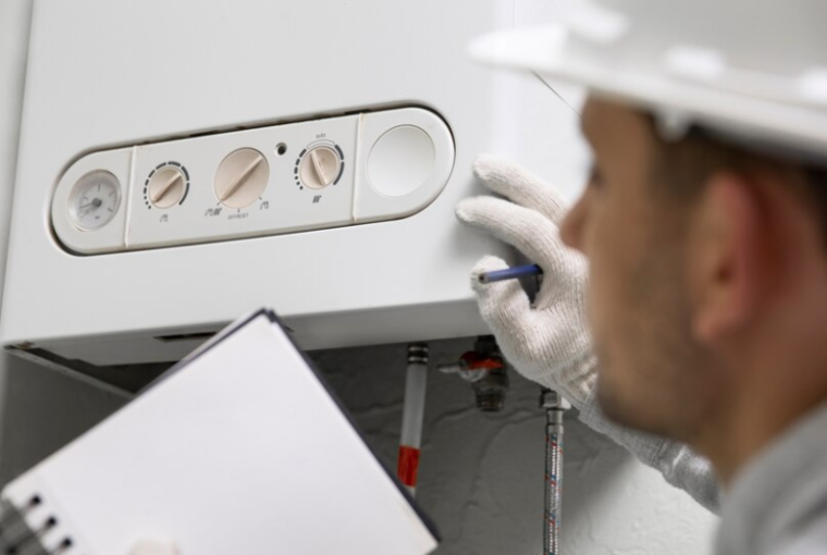 Man in white safety hat looking at a boiler