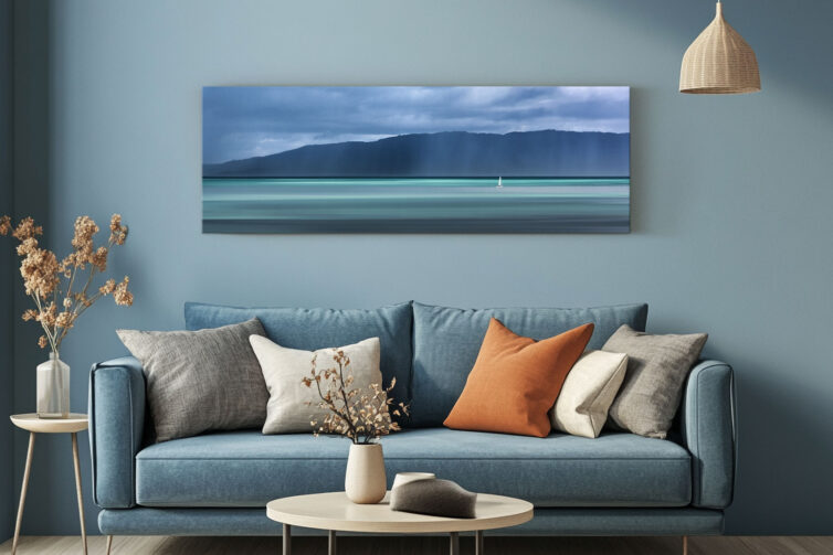 Living room with blue sofa and coffee table, with wall art above the sofa - stormy light canvas